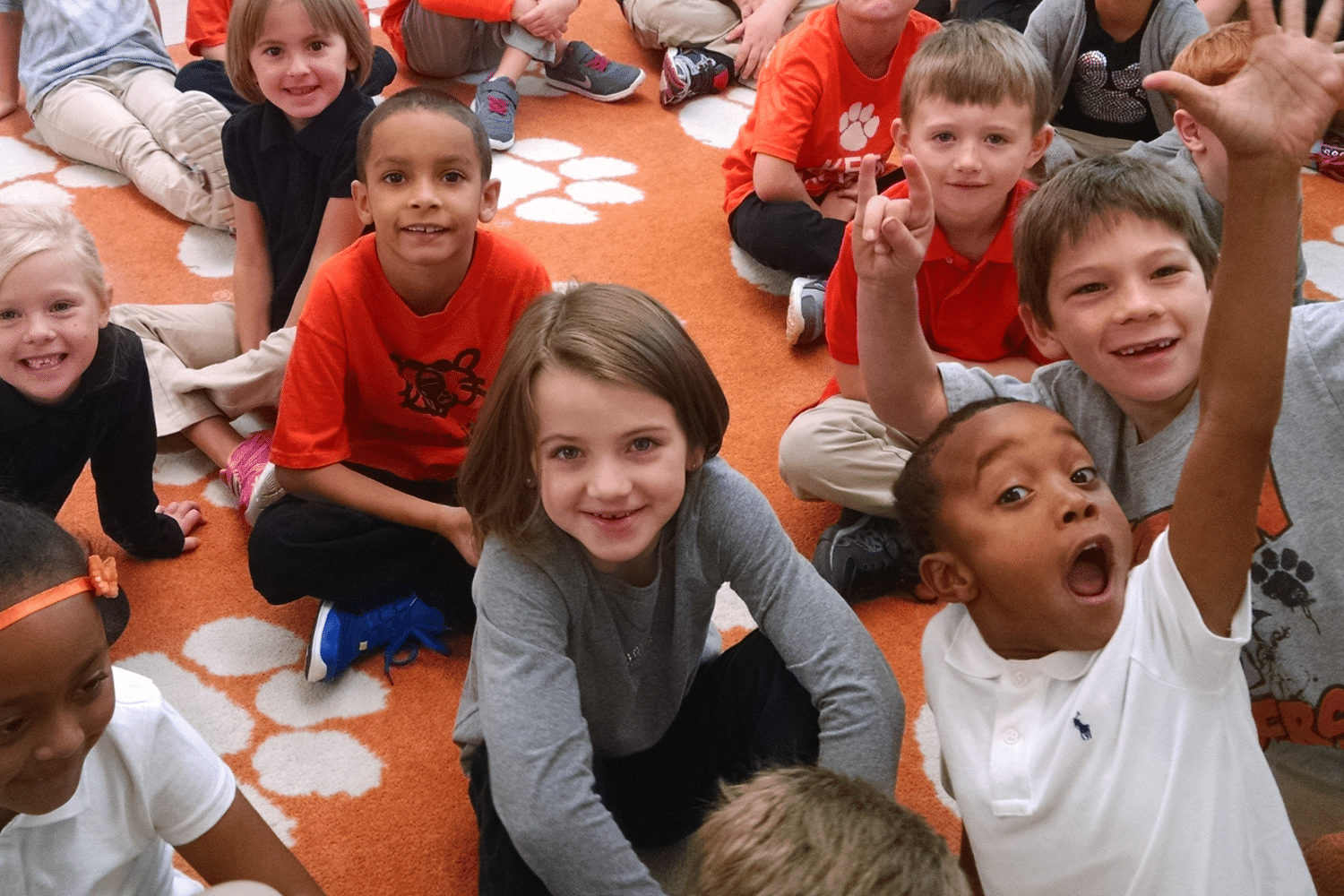 excited students sitting on the carpet